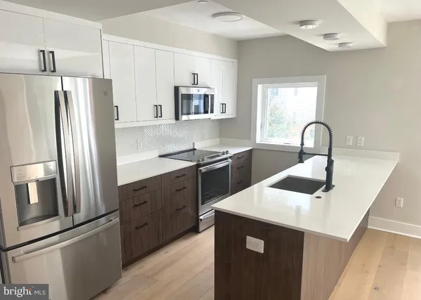 a kitchen with a refrigerator sink and cabinets