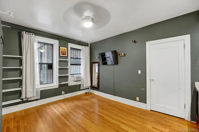 a view of an empty room with furniture and wooden floor