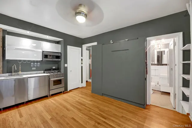 a kitchen with stainless steel appliances kitchen island granite countertop a refrigerator and a stove top oven