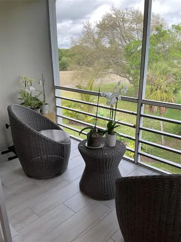 a view of a chairs and table in the balcony