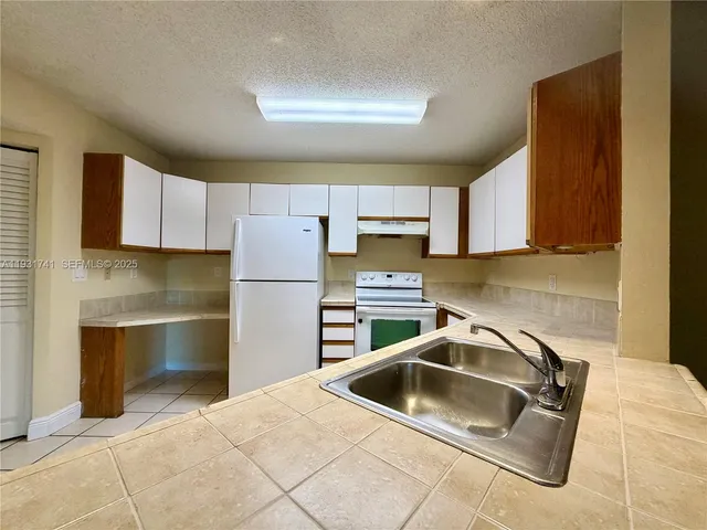 a kitchen with a sink cabinets and stainless steel appliances