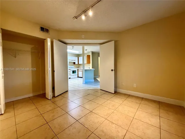a view of a livingroom with wooden floor and a refrigerator