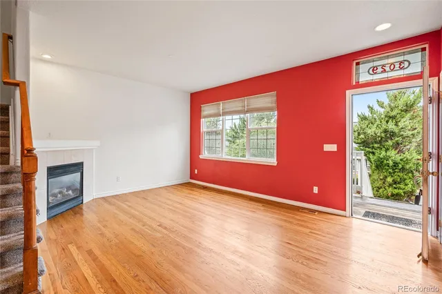 an empty room with windows and a fireplace