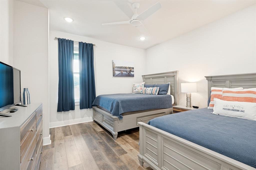 3412 Scenic Point Road, Unit 102 Graford, TX 76449 - Photo 19 of 31 a bedroom with two beds and a flat screen tv