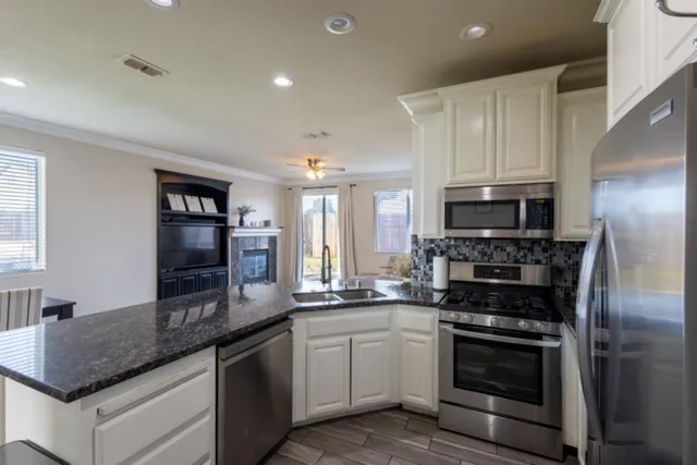 a kitchen with stainless steel appliances granite countertop a stove a sink and a refrigerator
