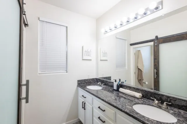 a bathroom with a granite countertop sink and a mirror