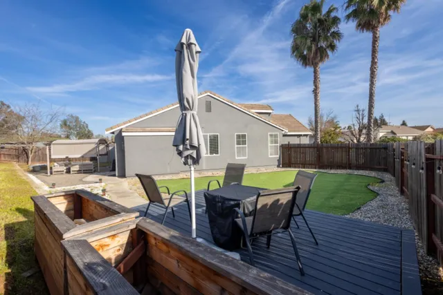 a view of a roof deck with table and chairs couches with wooden fence