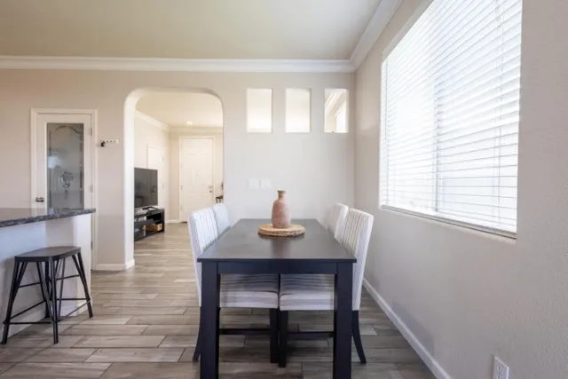 a view of a a dining room with furniture window and wooden floor