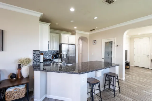 a kitchen with granite countertop kitchen island stainless steel appliances a table and chairs