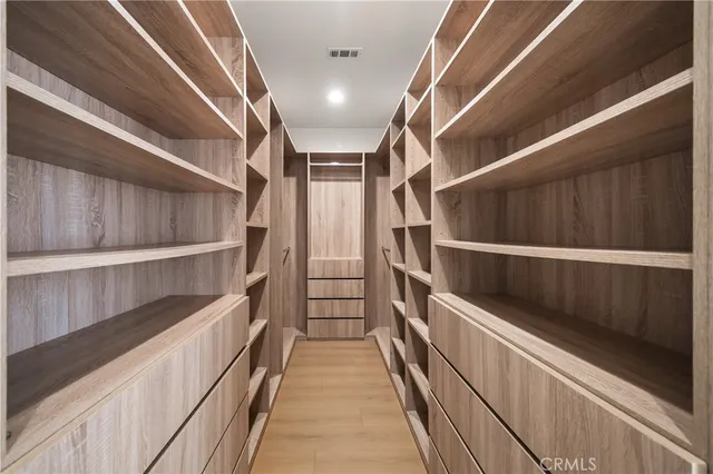 a view of walk in closet with empty racks