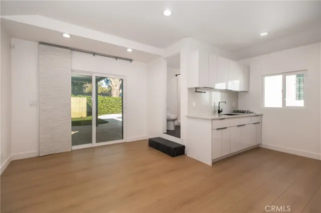 a kitchen with granite countertop a white stove top oven cabinets and a refrigerator