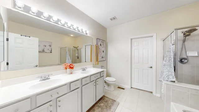 a spacious bathroom with a double vanity sink mirror and double