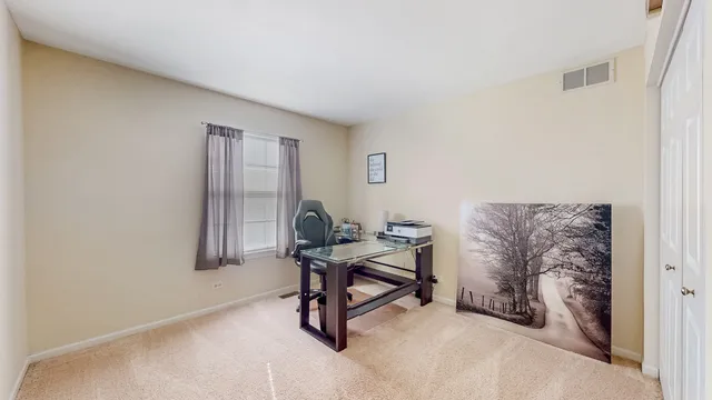 a view of a workspace with furniture and a window