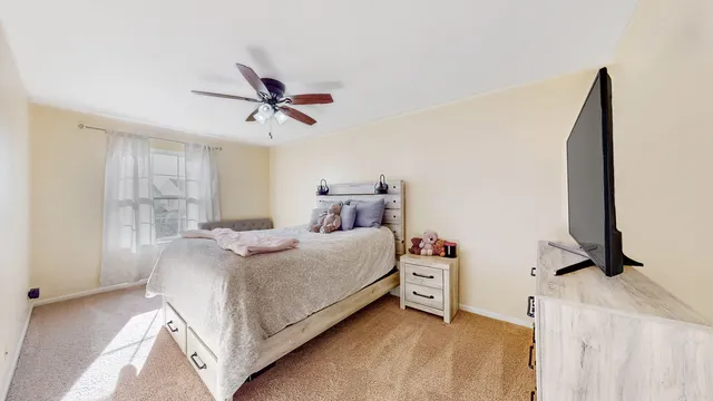 a bedroom with a bed and a ceiling fan