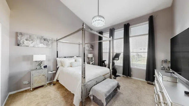 a bedroom with a bed a large window and flat screen tv