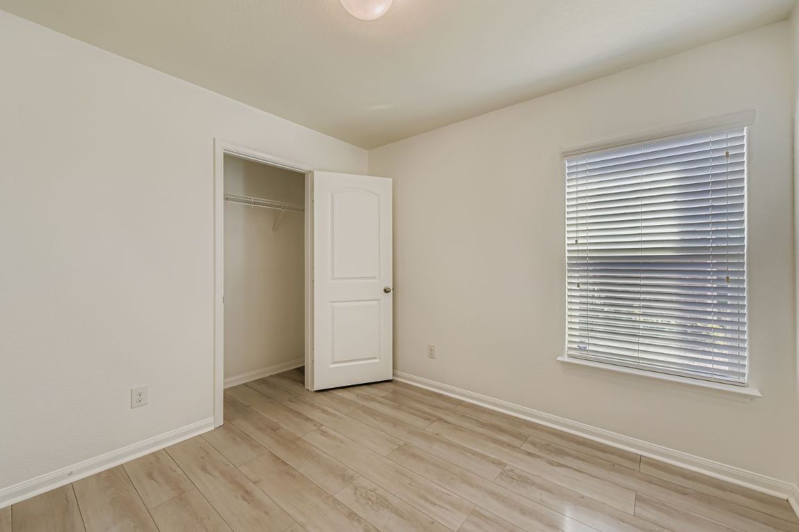 232 Millers Loop Jarrell, TX 76537 - Photo 20 of 34 an empty room with wooden floor and windows