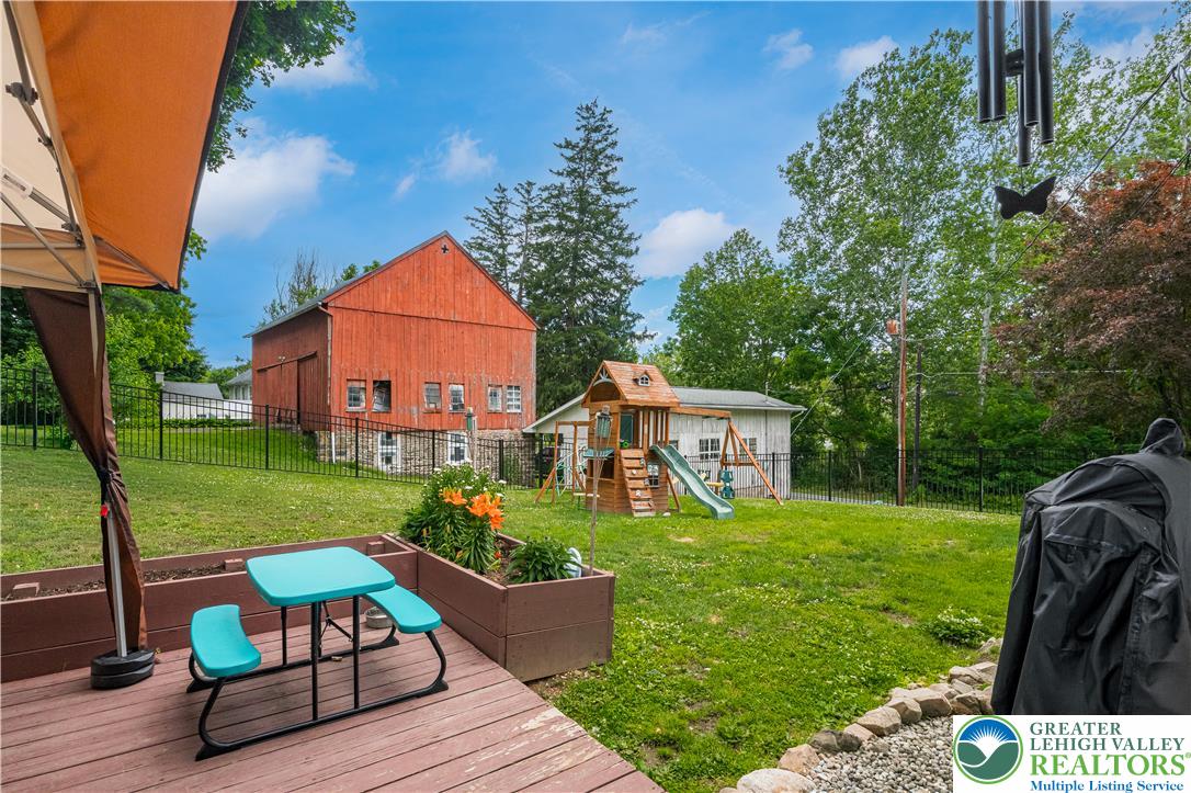 50 Kohls Road Northampton, PA 18067 - Photo 37 of 54 A vibrant backyard with a spacious deck, manicured lawn, and a charming play area.
