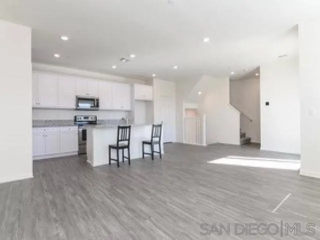 365 Fitzpatrick Road, Unit 102 San Marcos, CA 92069 - Photo 4 of 11 a view of kitchen with kitchen island microwave and cabinets