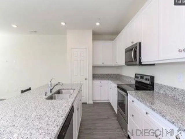 365 Fitzpatrick Road, Unit 102 San Marcos, CA 92069 - Photo 5 of 11 a kitchen with stainless steel appliances granite countertop a sink stove and cabinets