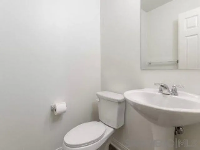 365 Fitzpatrick Road, Unit 102 San Marcos, CA 92069 - Photo 8 of 11 a bathroom with a sink a toilet and mirror