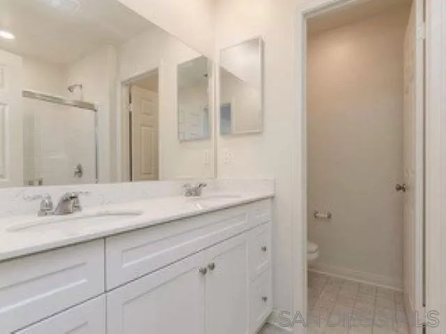 365 Fitzpatrick Road, Unit 102 San Marcos, CA 92069 - Photo 9 of 11 a bathroom with a granite countertop sink and a mirror