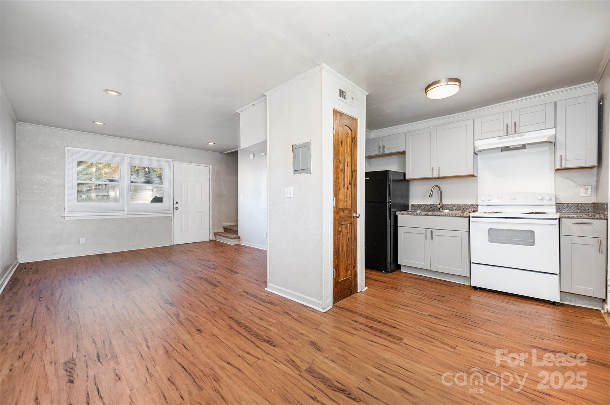 2407 Julia Avenue, Unit 3 Charlotte, NC 28206 - Photo 5 of 13 a kitchen with white cabinets and wooden floor