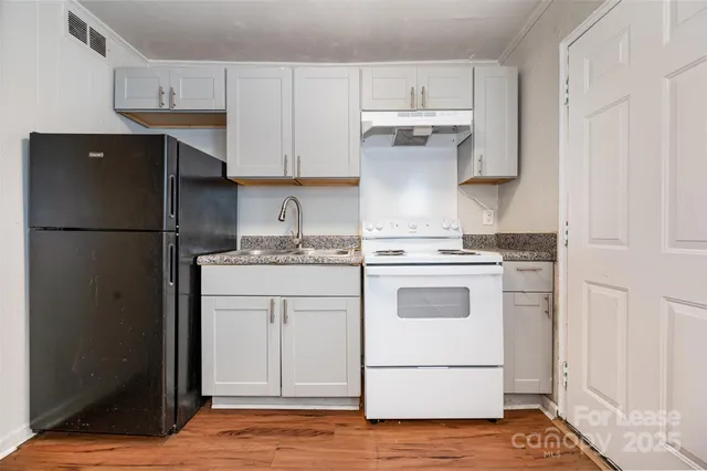 a kitchen with a refrigerator sink stove and cabinets