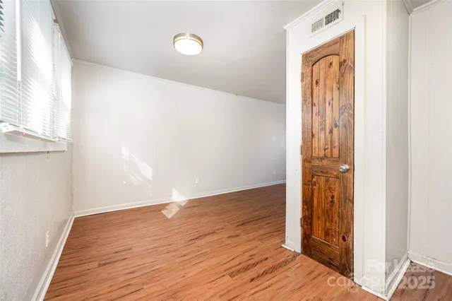 an empty room with wooden floor and a window