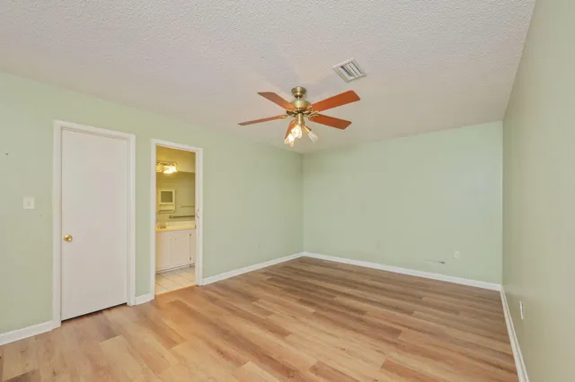 a view of a room with wooden floor and a ceiling fan