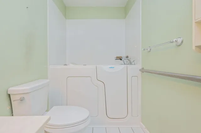 a white toilet sitting next to a shower