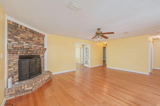 a view of empty room with wooden floor and fireplace
