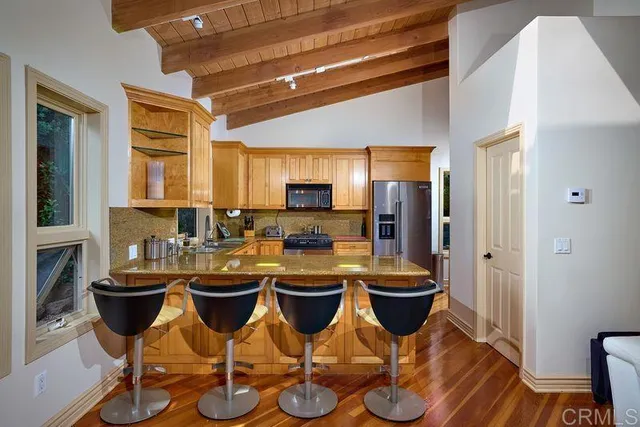 a kitchen with stainless steel appliances granite countertop a stove a sink and a microwave