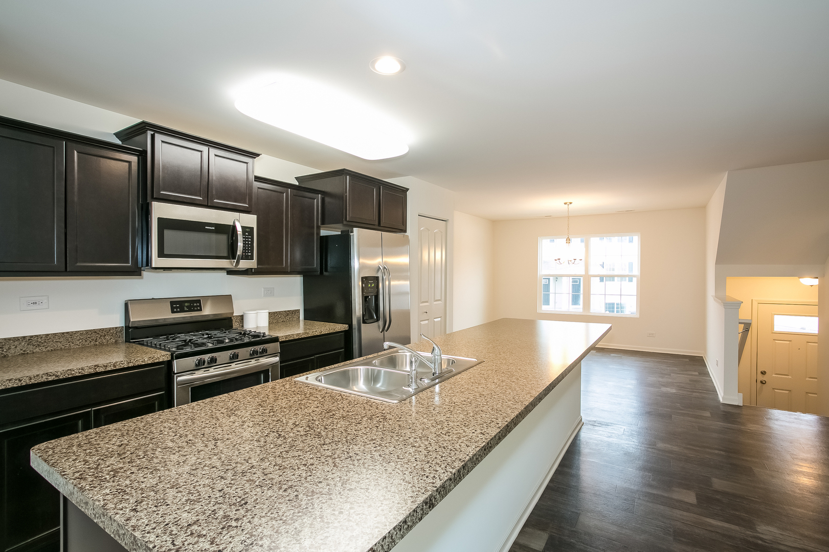 2369 Upland Road Pingree Grove, IL 60140 - Photo 2 of 18 a kitchen with stainless steel appliances granite countertop a sink a stove counter space and wooden floor