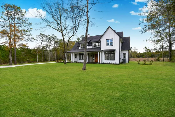a front view of a house with a yard and trees
