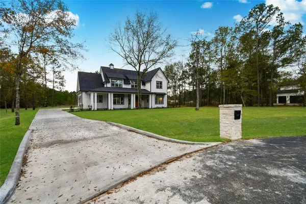 a front view of a house with a garden and trees