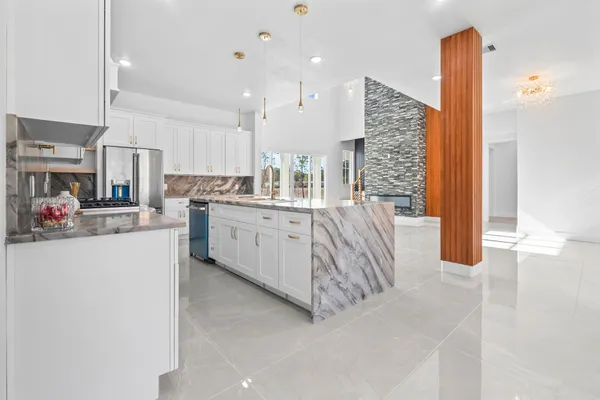 a kitchen with stainless steel appliances granite countertop a stove a sink and a refrigerator