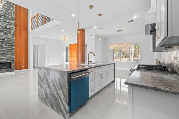 a kitchen with stainless steel appliances granite countertop a sink and a stove