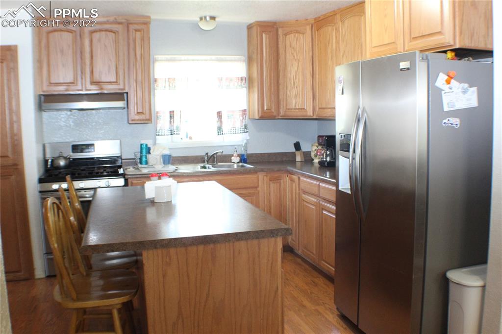 29454 County Farm Road Pueblo, CO 81006 - Photo 5 of 25 a kitchen with stainless steel appliances granite countertop a refrigerator a sink a stove a table and chairs