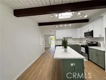 a kitchen with a sink a microwave and cabinets
