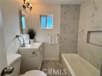 a bathroom with a sink a toilet a mirror and shower