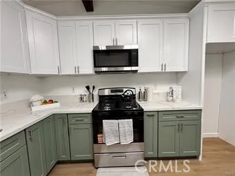 a kitchen with granite countertop white cabinets and black appliances