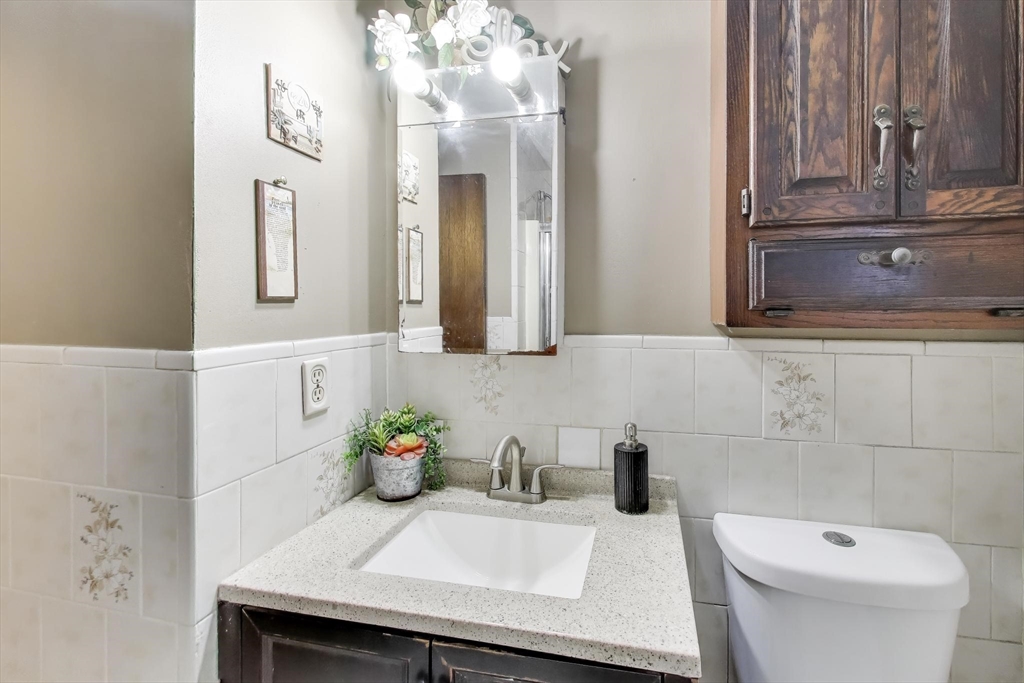 3 River St Court Lynn, MA 01905 - Photo 15 of 24 a bathroom with a granite countertop sink a toilet and mirror