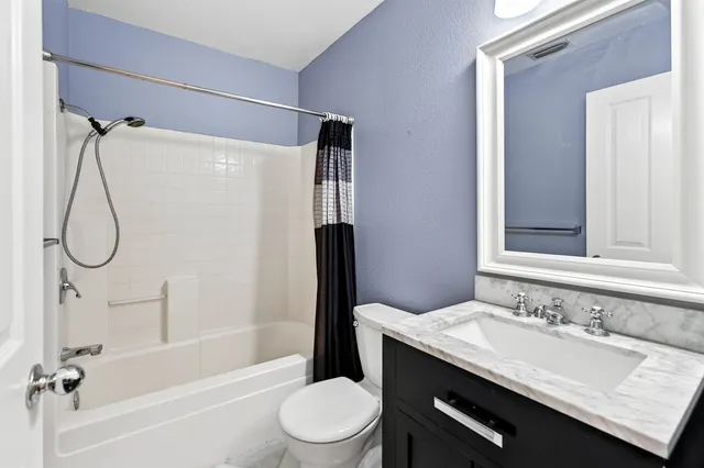 a bathroom with a granite countertop sink toilet and shower
