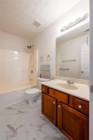 a spacious bathroom with a sink a toilet a mirror and bathtub
