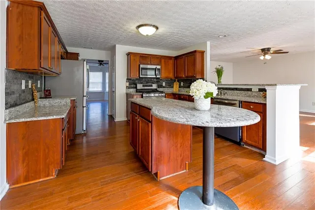 a kitchen with stainless steel appliances granite countertop a sink a stove and refrigerator