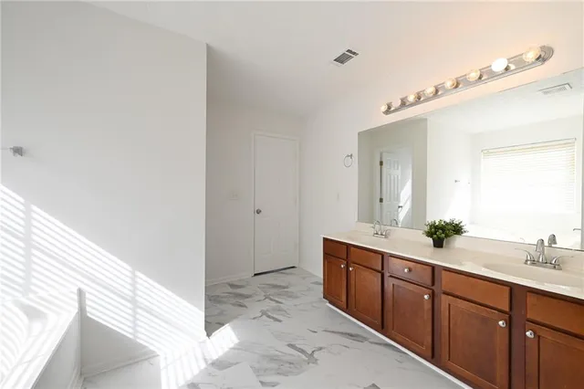 a spacious bathroom with a double vanity sink and a mirror