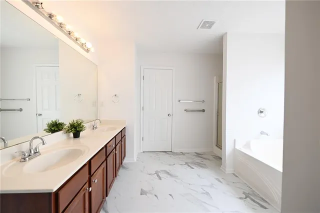 a bathroom with a sink and mirror with shower