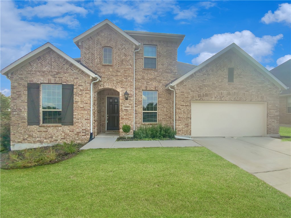 a front view of a house with a yard and garage