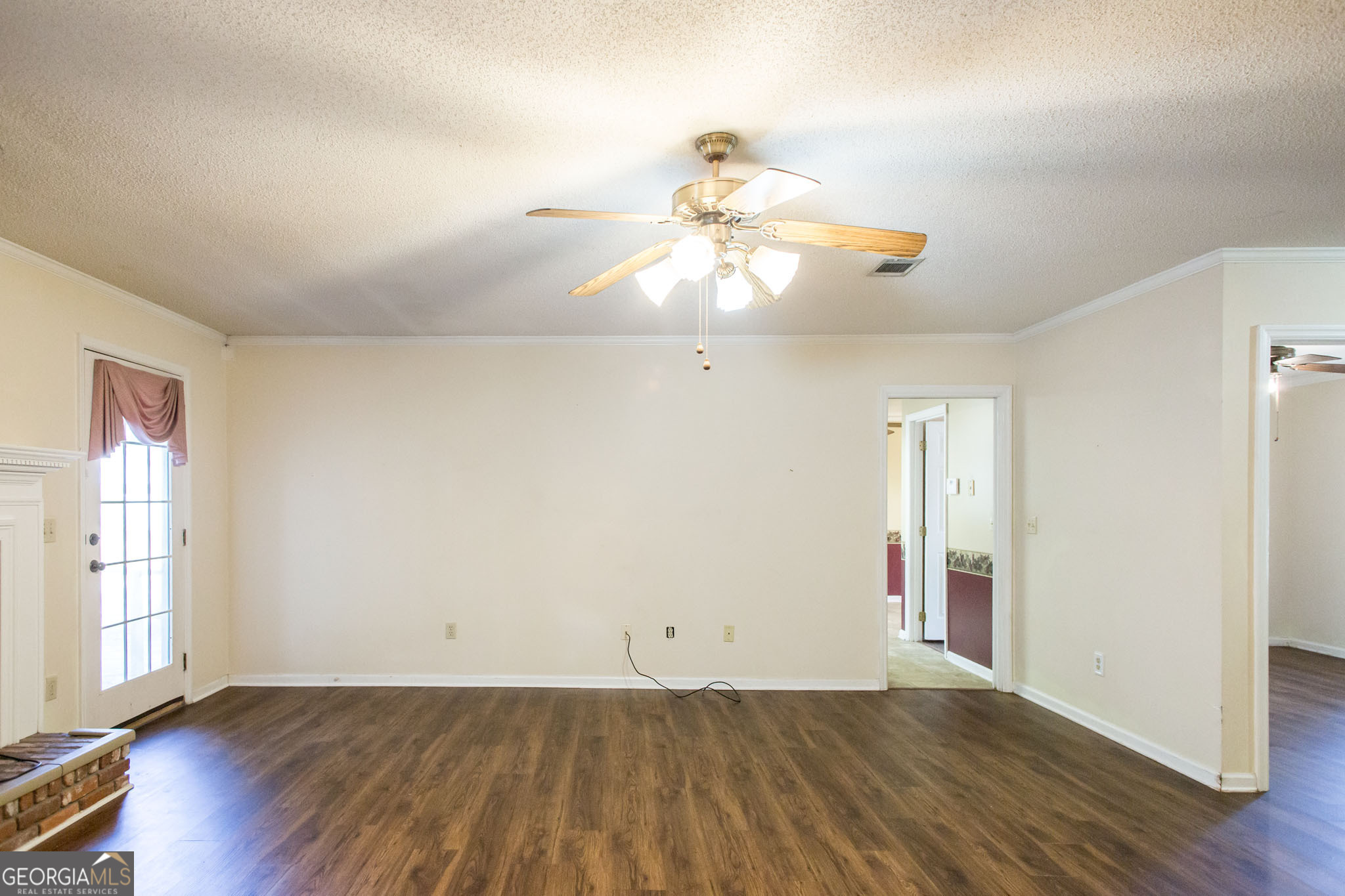2959 Chadwick Drive Waycross, GA 31501 - Photo 18 of 52 an empty room with wooden floor chandelier fan and windows