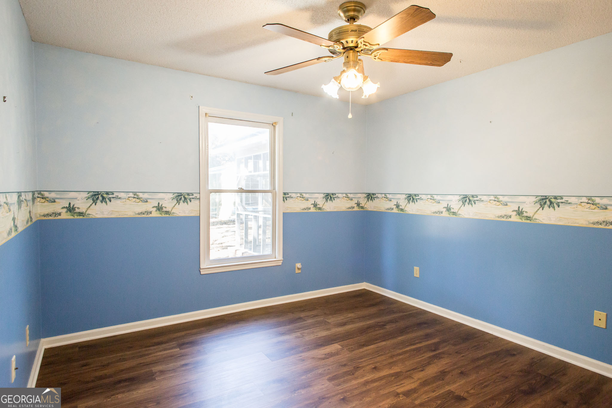 2959 Chadwick Drive Waycross, GA 31501 - Photo 39 of 52 an empty room with wooden floor fan and windows